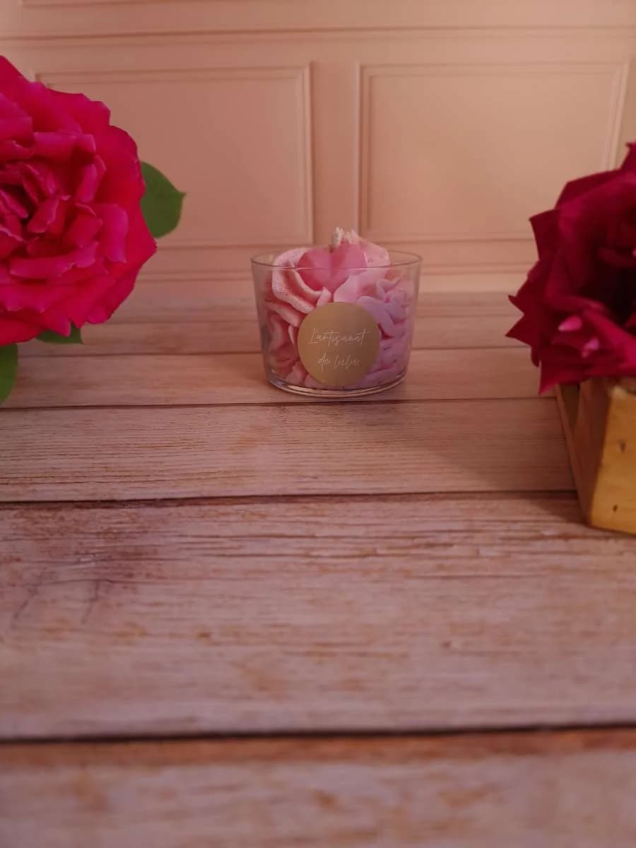 Vue d'ensemble de la bougie gourmande rose dans son verre transparent sur une table en bois